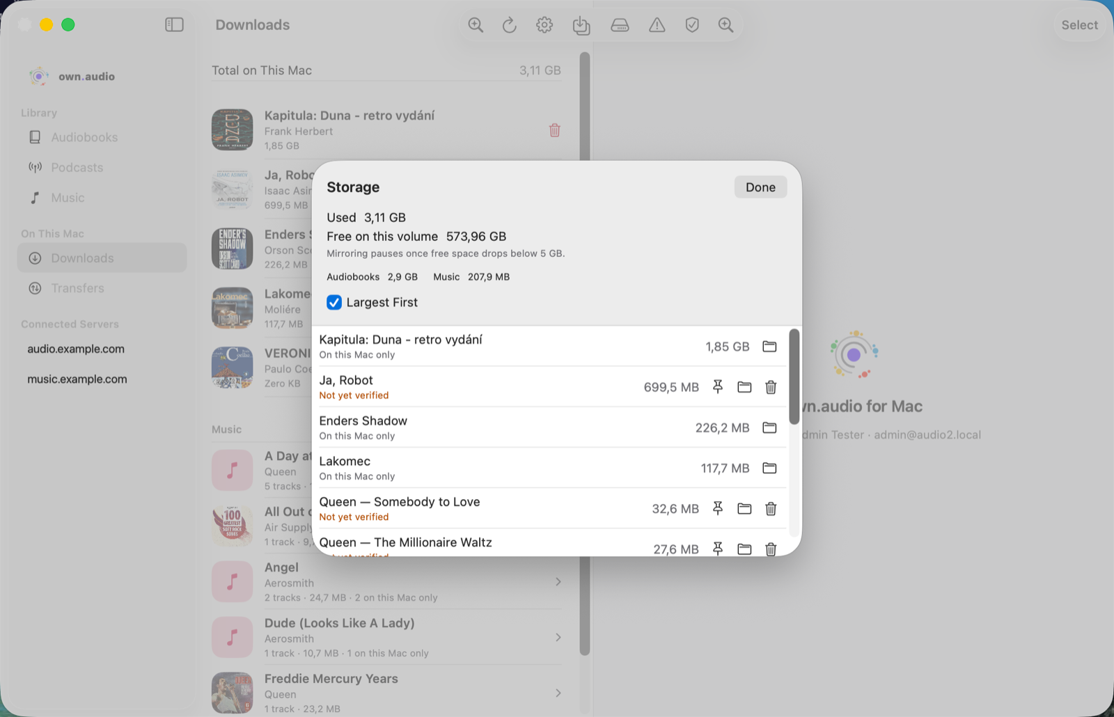 The Storage sheet in the own.audio Mac app, showing 3.11 GB used, 574.6 GB free on the volume, a note that mirroring pauses below 5 GB, per-kind totals for Audiobooks and Music, and a list of items sorted largest first with pin, reveal, and remove buttons.